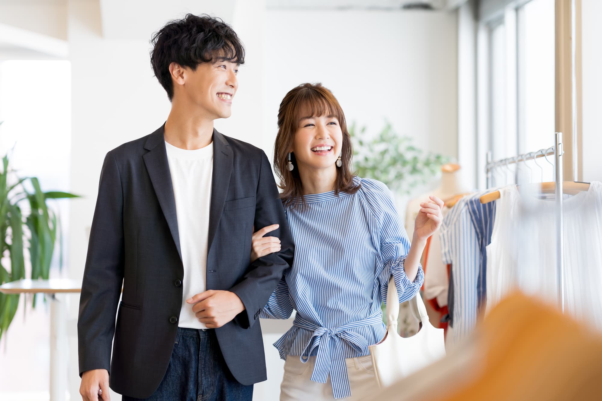 腕を組みショッピングを楽しむ男女