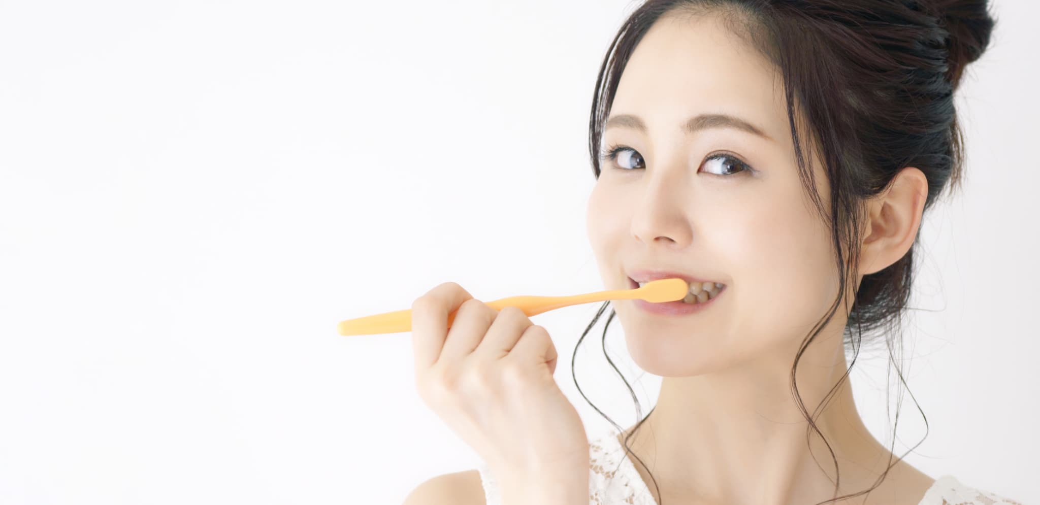 オフィスホワイトニング後の白い歯を守るために丁寧に歯磨きをする女性