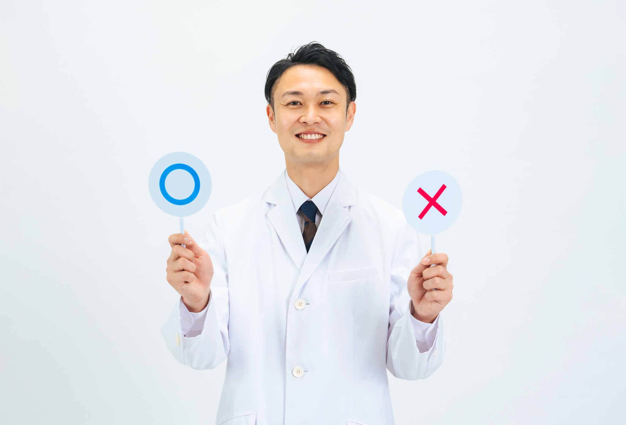 矯正で歯を削るケースと削らないケースについて説明する歯科医