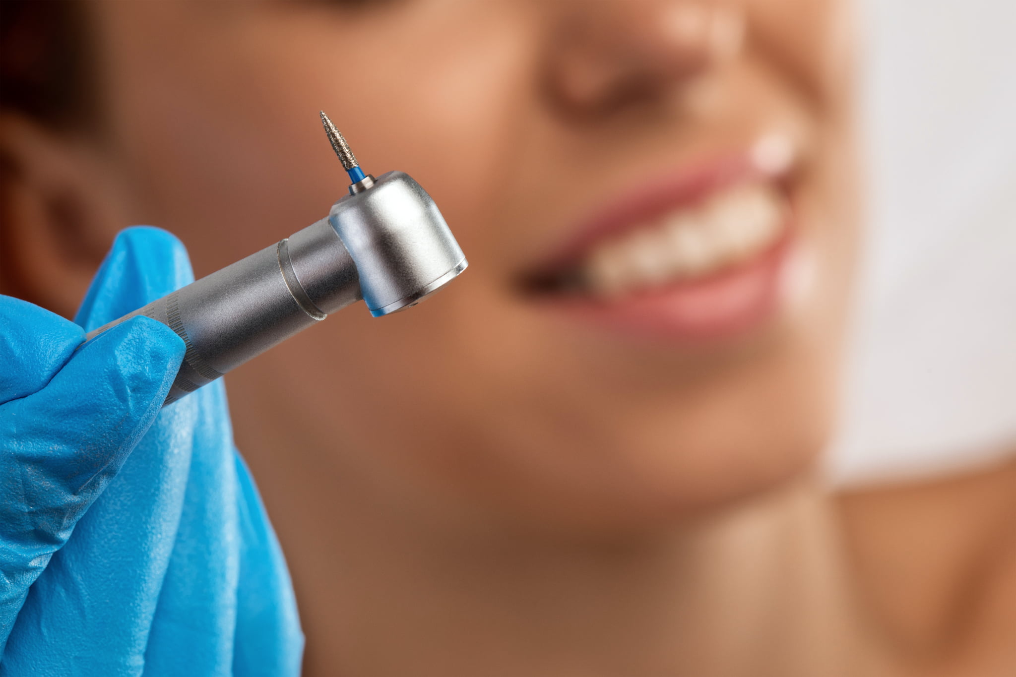 矯正治療で歯を削る医療器具と患者のイメージ