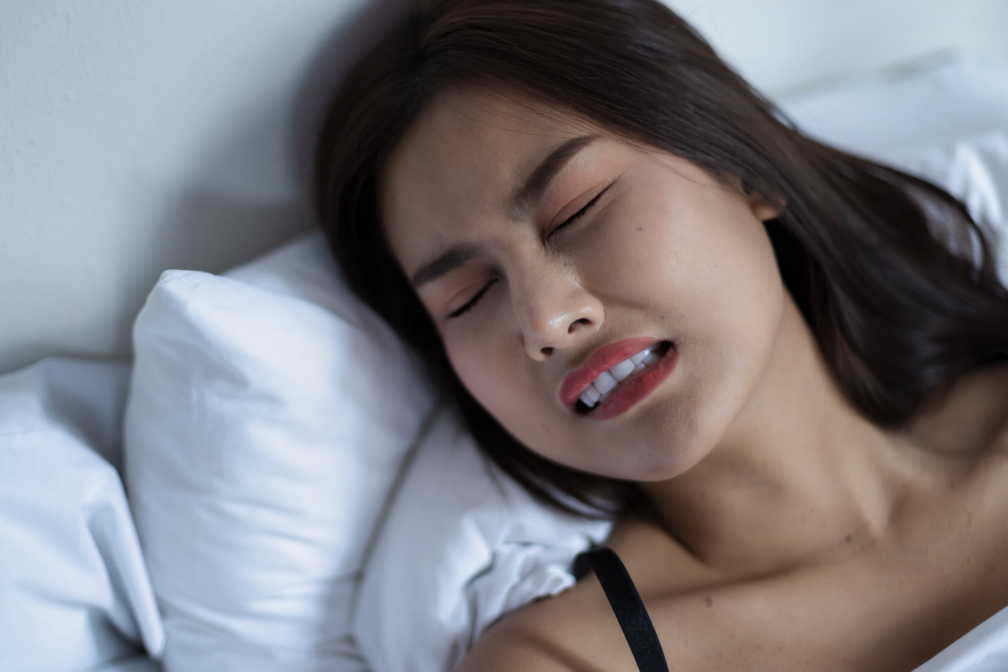 歯ぎしりして眠る女性