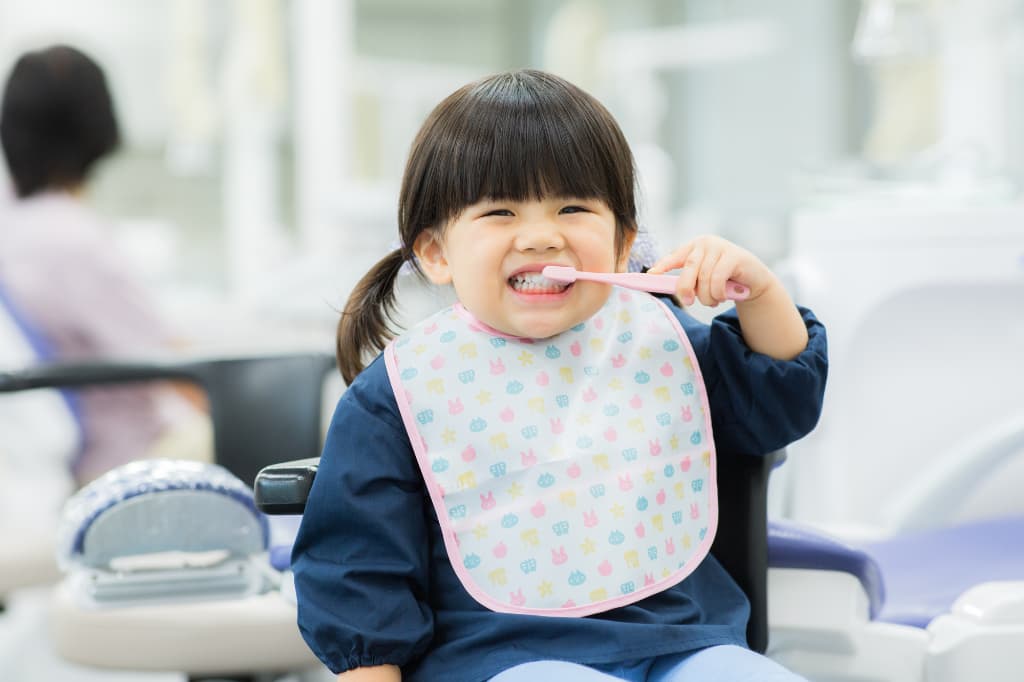 歯科医院で歯磨きの練習をする子ども