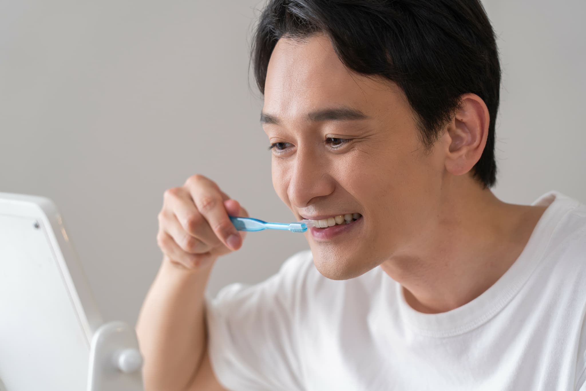 ブラッシング指導で教わった歯ブラシの持ち方や動かし方を自宅でも実践する男性