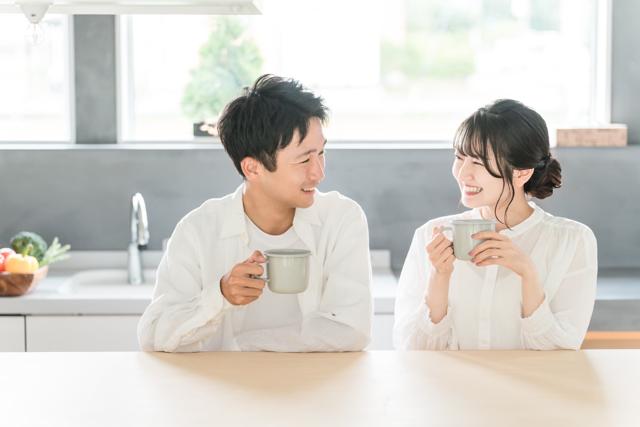 マグカップを持ちリラックスした雰囲気の夫婦