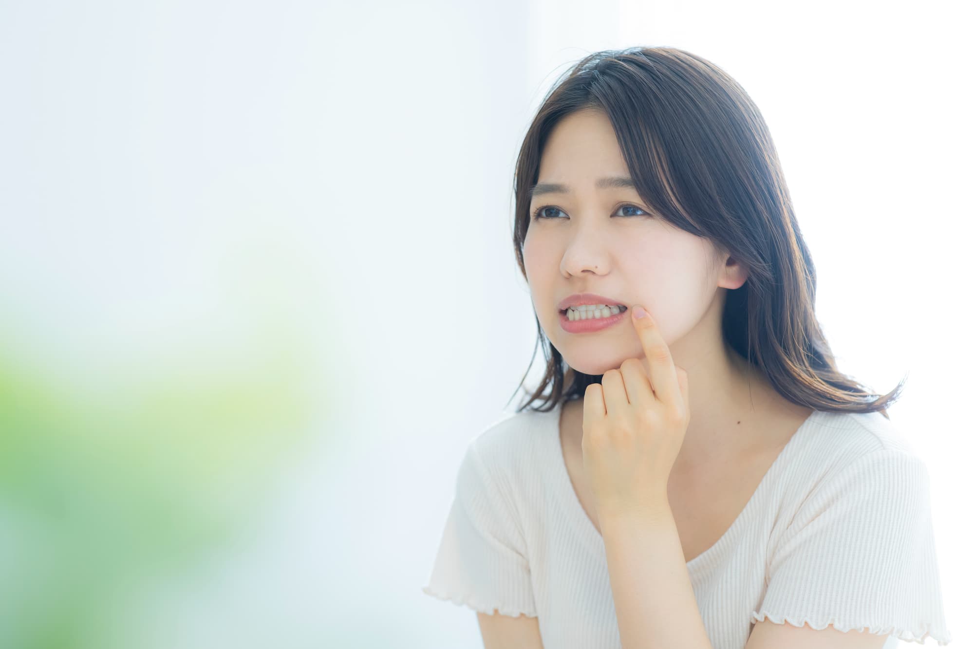 矯正中に虫歯ができて気にしている女性