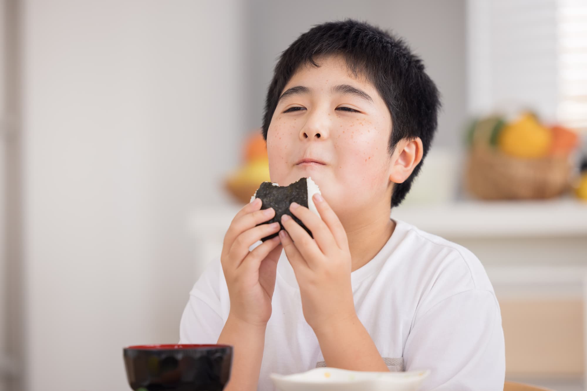 おにぎりをおいしそうに食べる男の子