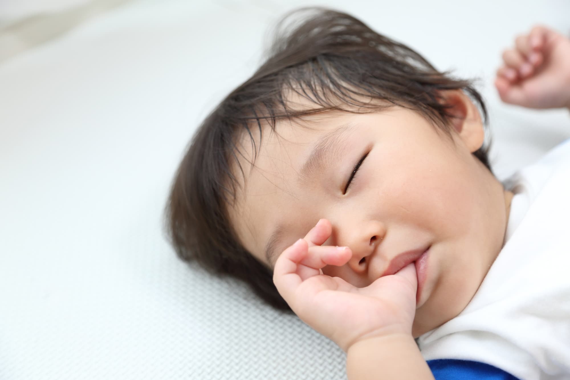 指しゃぶりしながら眠る子供